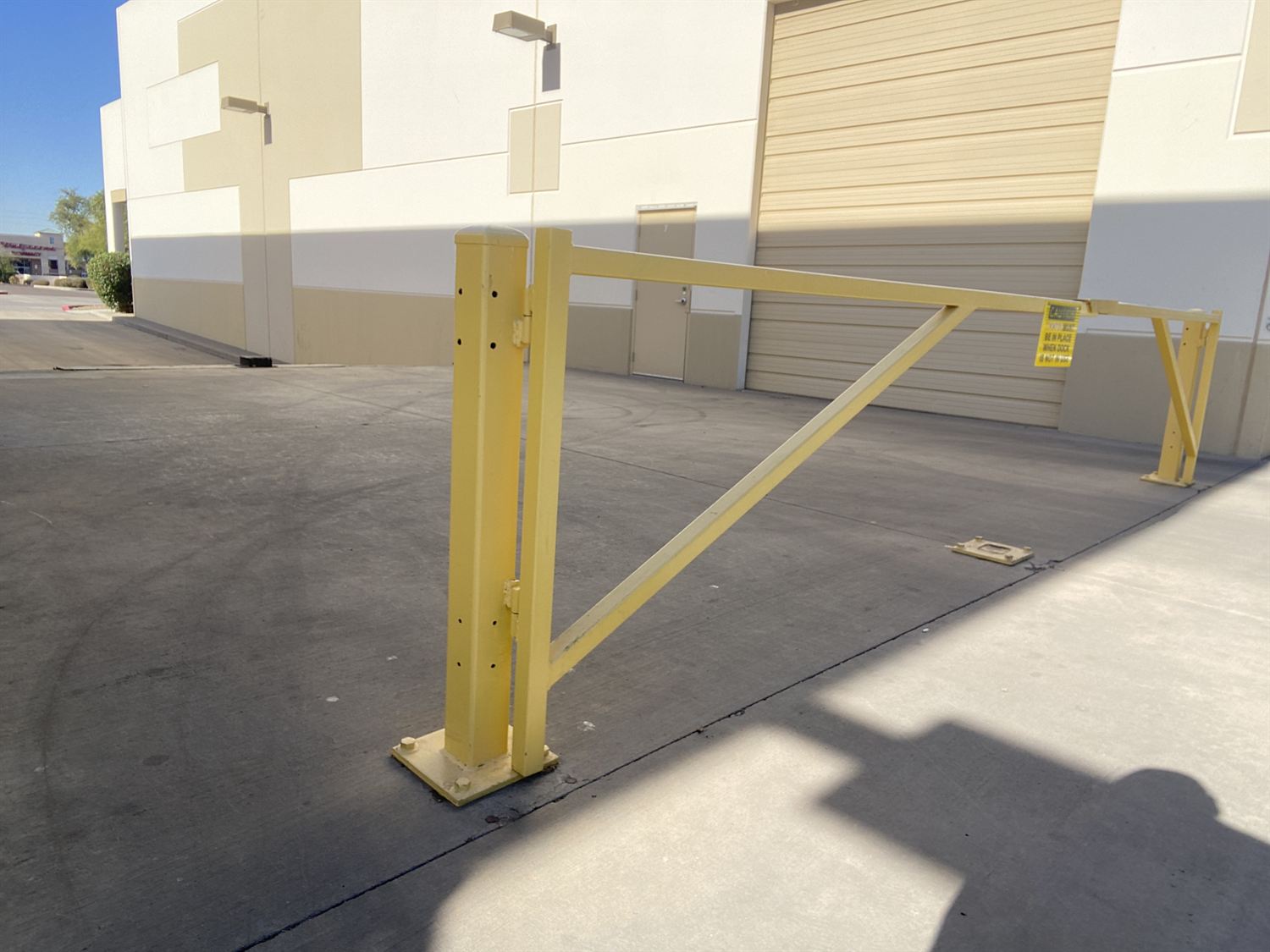 Yellow steel swing gate at a commercial loading dock