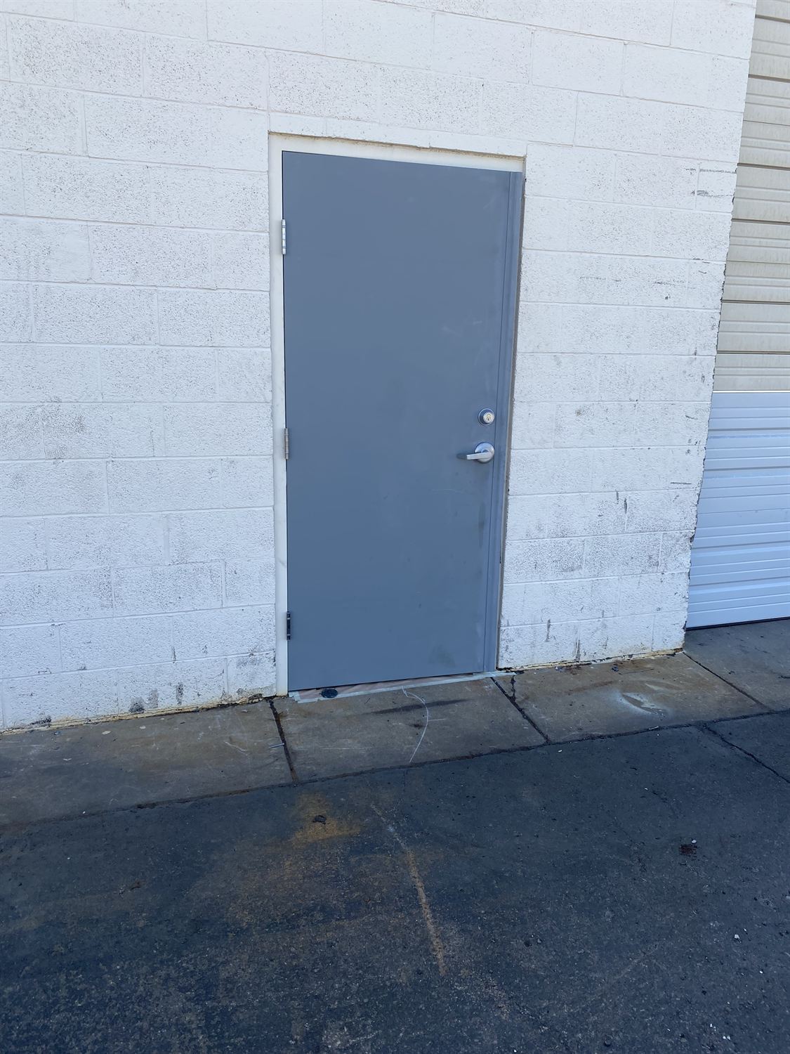 New gray commercial steel entry door after replacement