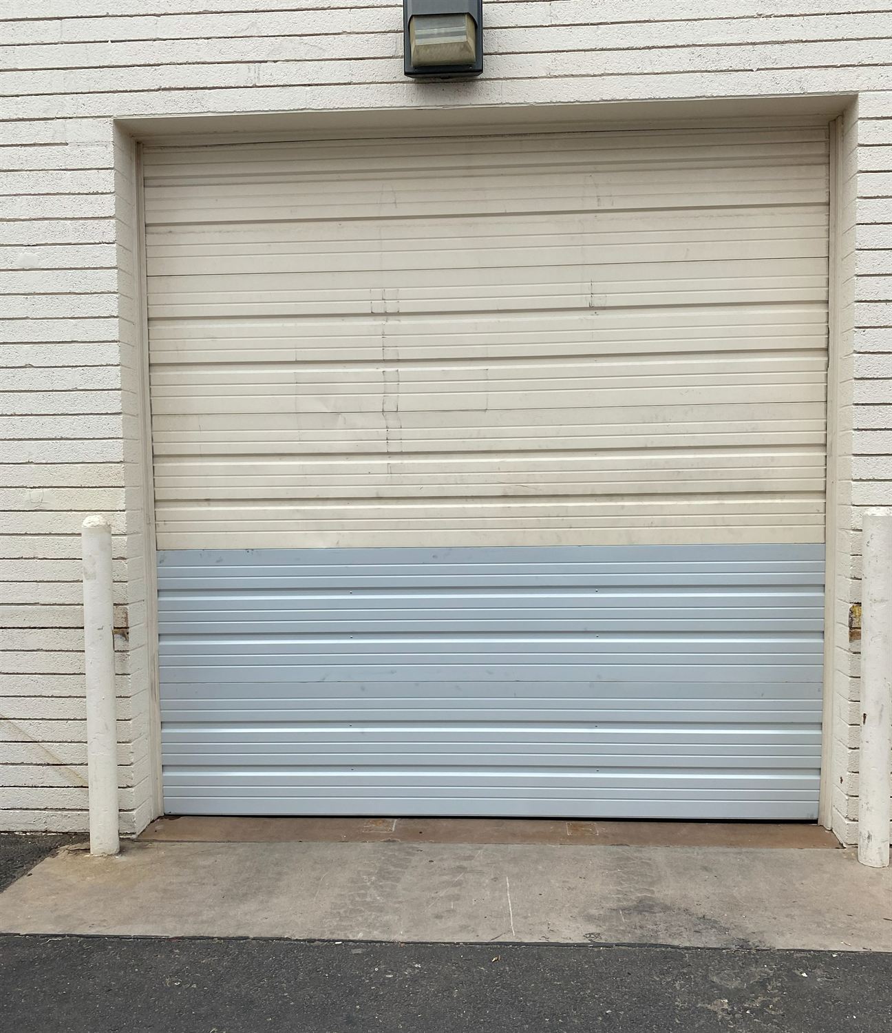 Commercial garage door after a bottom-section panel replacement